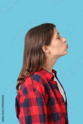Young woman kissing on blue...