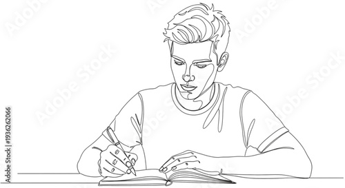 A young man sits at a table, intently writing in a book with a pen.