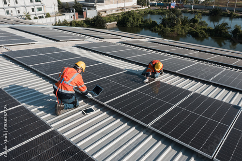 Принти на полотні Top view workers installing solar panel array on large factory roof under bright sunlight, using professional tools to assemble photovoltaic system supporting clean energy transition