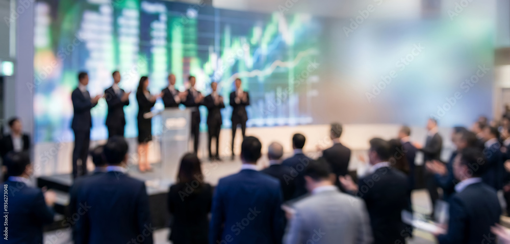 Fototapeta premium Fully blurred IPO celebration stage with executive silhouettes and audience shapes.