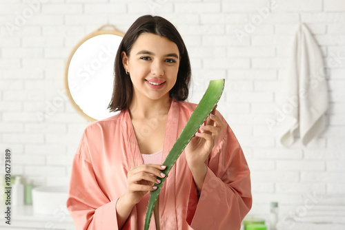 Happy young woman with aloe...
