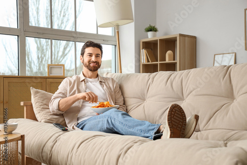 Man eating tasty nachos whi...