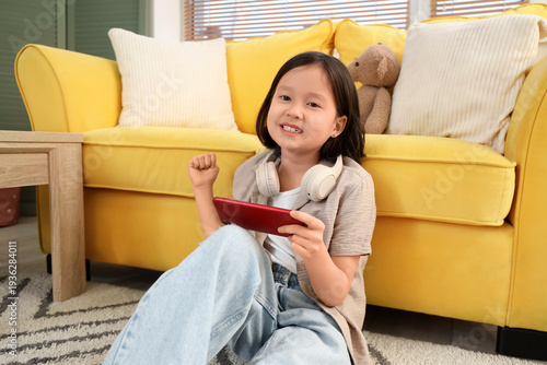 Cute little Asian girl usin...