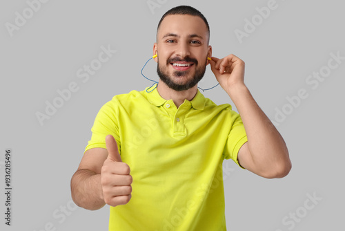 Young man with earplugs sho...