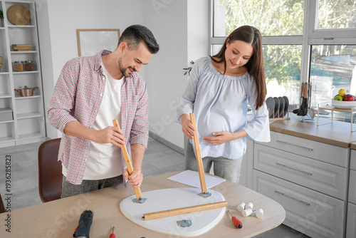 Happy pregnant couple assem...