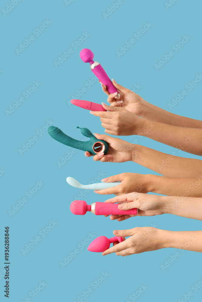 Fototapeta premium Women with vibrators on blue background