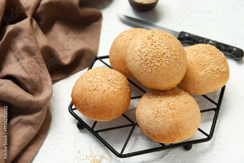 Obraz na plátně Stand of fresh buns with sesame seeds on white background