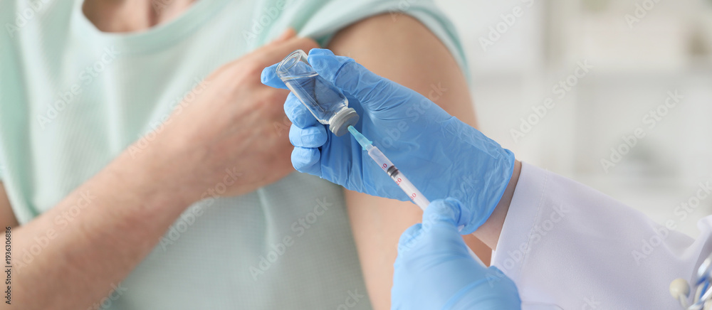 Fototapeta premium Doctor vaccinating man in clinic, closeup