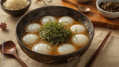 Tteokguk: Oval rice cake soup in broth with seaweed