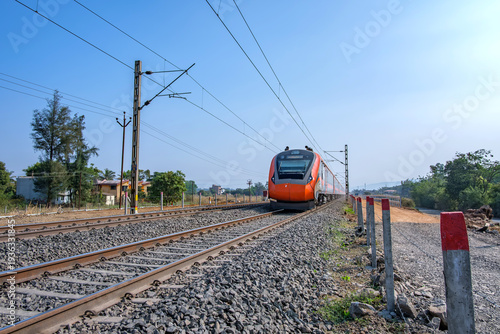 Saffron coloured Vande Bharat Express near Pune India. This is a made in India train set and also known as Train 18.
