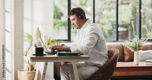 Businessman, agent and laptop with headset in home for online advice or customer service. Man, freelance consultant or remote work with computer for virtual assistance, web support or help in house