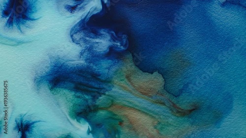 Abstract blue and teal watercolor paint blends organically on textured paper