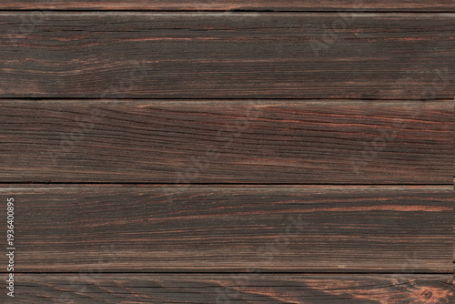 Dark brown wooden planks laid horizontally create a rustic textured backgroun...