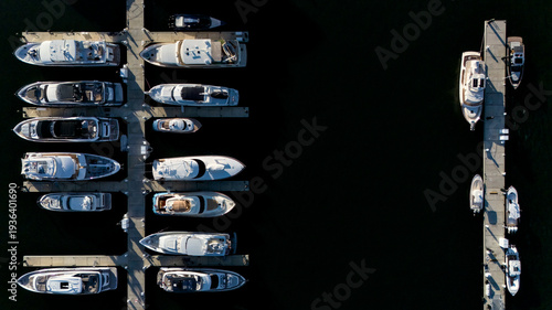 Top down drone photo of yachts and boats docked in marina with copy space