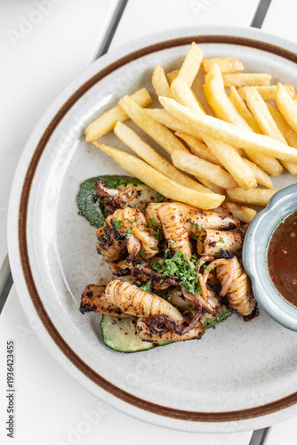 Wallpaper Mural mediterranean style grilled squid with escabeche sauce and fries on white table at ibiza spain restaurant Torontodigital.ca