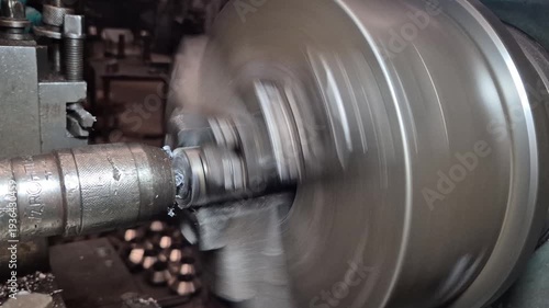 The lathe is rotating to create a workpiece from metal and thread.