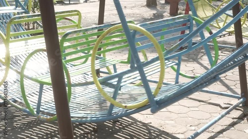 A metal rocking chair in the playground, situated in a quiet outdoor play area, is perfect for relaxation and outdoor activities.