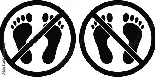 Two black and white no walking signs with footprints