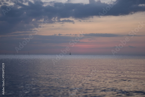 Bild auf Leinwand Sunset over the beach with boats in the background