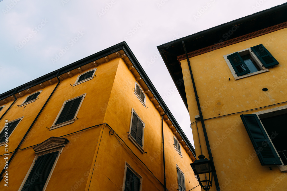 Obraz premium Buildings in Riva del Garda with yellow walls and dark shutters