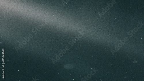 Dust motes floating in a dark textured background with a soft light beam abstract stock