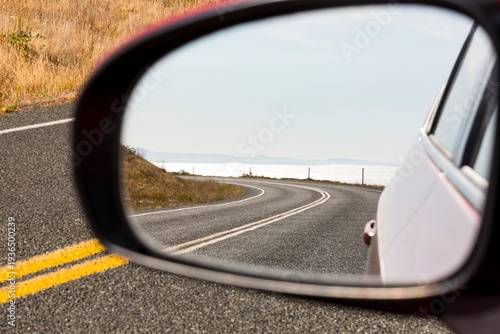 Cattle Pass Road, a curving road along the coast, view in the rear view mirror.
