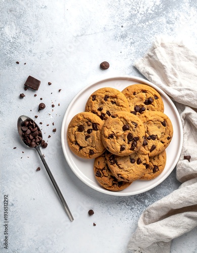 A plate of chocolate chip cookies on a table with a spoon