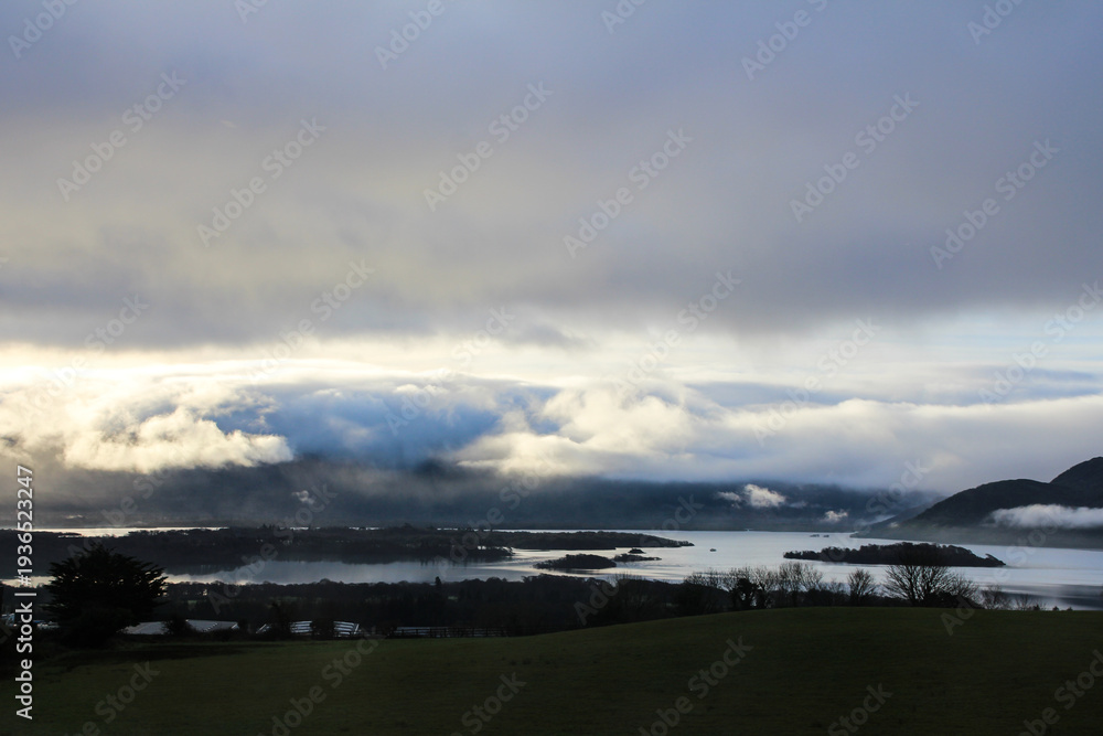 Obraz premium Dramatic clouds over lake and mountains at sunset