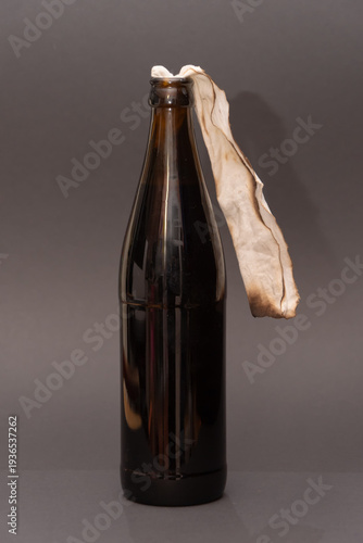 Fotografie Improvised incendiary bottle with cloth wick on gray background