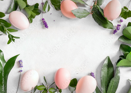 Easter spring background in rustic style: natural brown chicken eggs, fresh lavender, green branches and leaves, on a natural linen tablecloth.