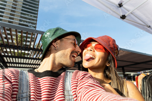 Cheerful couple taking outdoor selfie in urban summer setting