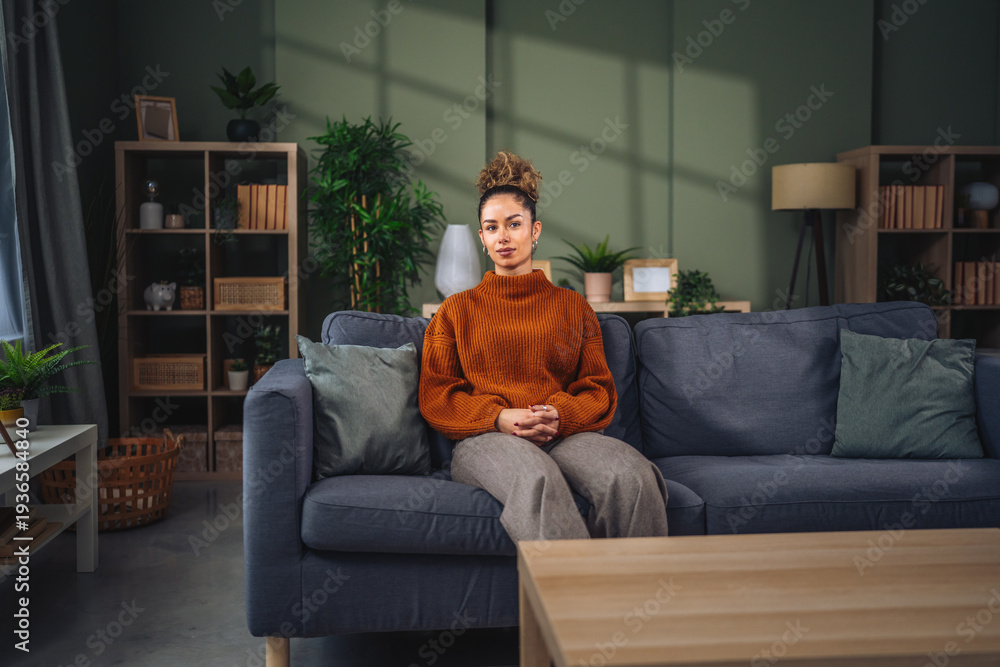 Obraz premium Young woman relaxing on sofa in modern living room