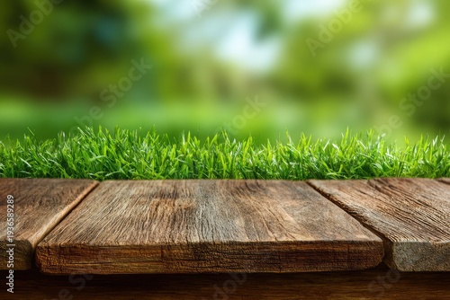 Rustic wooden planks on lush green grass with blurred background