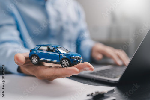 Wallpaper Mural Car insurance and loan approval concept. A miniature car placed on hand with insurance contract document policy agreement. vehicle finance, policy management, rental, sales, and claims service. Torontodigital.ca
