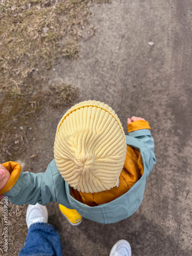 Top view of toddler holding parent hand on sidewalk Copy Space