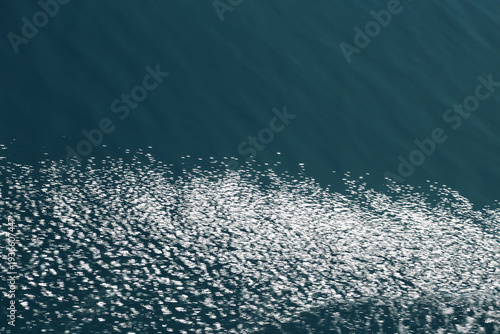 Фотография Sunlight sparkling on blue ocean water surface texture