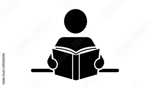A black silhouette of a person reading an open book sitting at a desk