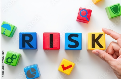 A hand placing a block with the letter K to spell out risk