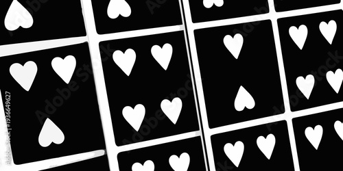 Close up of black playing cards displaying white heart suits