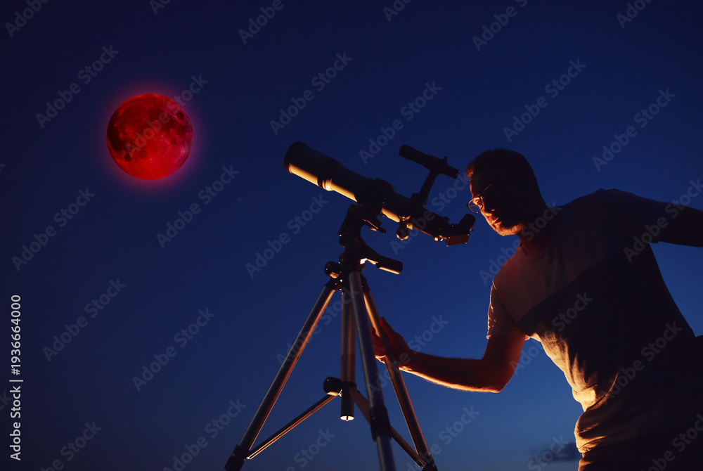 Fototapeta premium Amateur astronomer observing Lunar eclipse with a astronomical telescope.