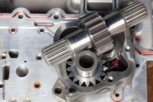 High angle view of disassembled steel transmission gears and splined drive shafts on metal workbench. Precision mechanical engine parts for industrial machinery maintenance and repair service.