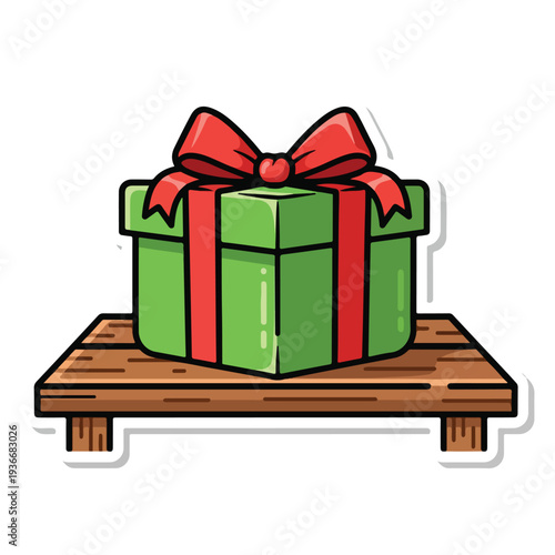 A green gift box with red ribbon on a wooden table viewed from the front