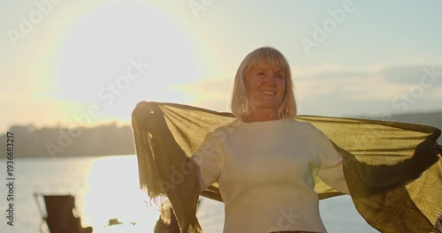 Senior woman enjoying a beautiful sunset by the lake