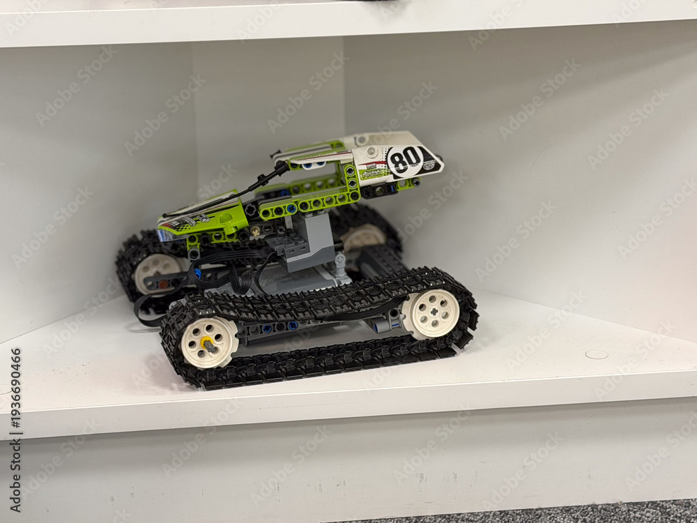 Fototapeta premium Green tracked toy vehicle on shelf