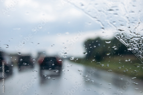 Rain drops on car windshield while driving on highway in rainy weather near Montreal