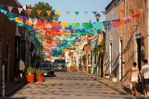 Fotografie Colorful papel picado flags adorn a charming street in Valladolid, Mexico