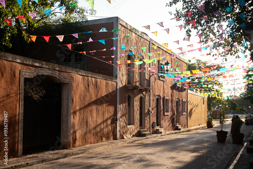 Colorful papel picado flags adorn a charming street in Valladolid, Mexico