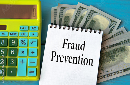 FRAUD PREVENTION - words in a notebook against the background of a calculator and banknotes