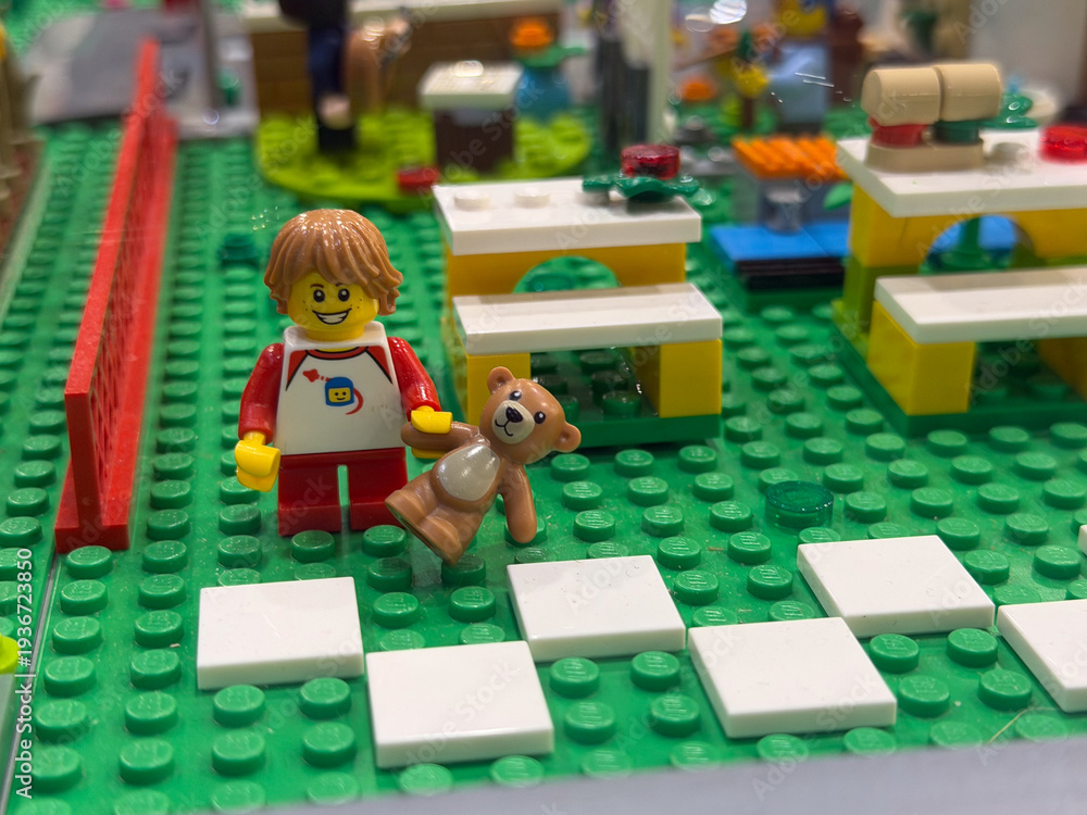 Fototapeta premium Lego child with teddy on green baseplate