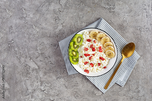 Healthy breakfast bowl with cottage cheese, fresh kiwi, banana slices and dried strawberries